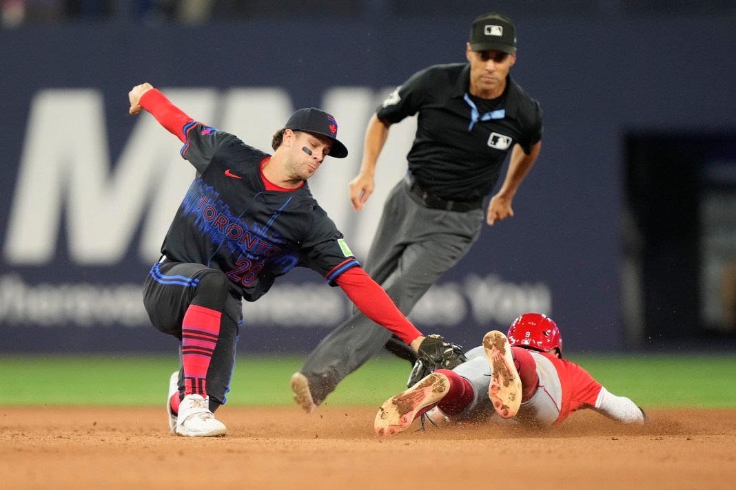 Toronto Blue Jays shortstop Ernie Clement (28) tags out Los Angeles Angels shortstop Zach Neto (9) at second base during the eighth inning of the game at Rogers Centre in Toronto, Ontario, on August 23, 2024.