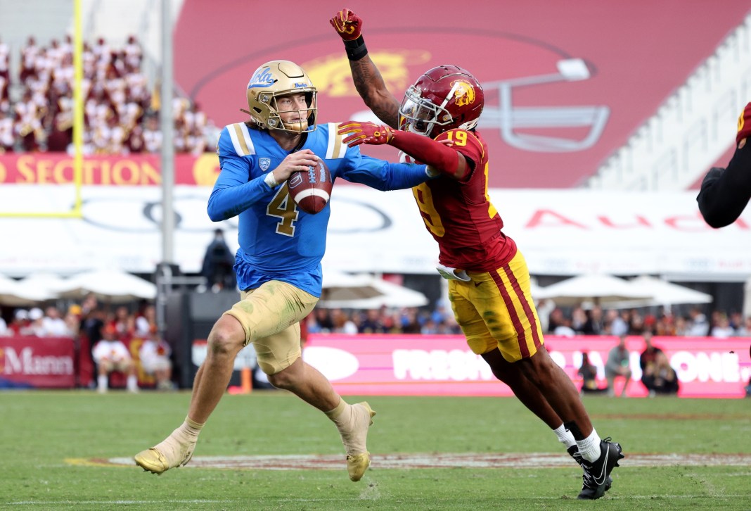 NCAA Football: UCLA at Southern California UCLA Bruins quarterback Ethan Garbers (4) scrambles to throw a touchdown under pressure from USC Trojans safety Jaylin Smith (19) during the third quarter at United Airlines Field at Los Angeles Memorial Coliseum on November 18, 2023.