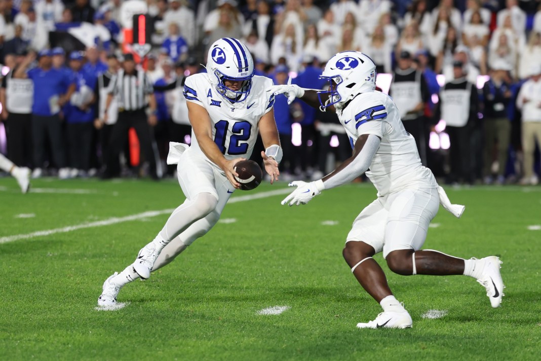 Brigham Young Cougars quarterback Jake Retzlaff (12) fakes a handoff to running back Miles Davis (4) during the first quarter against the Kansas State Wildcats at LaVell Edwards Stadium on September 21, 2024.