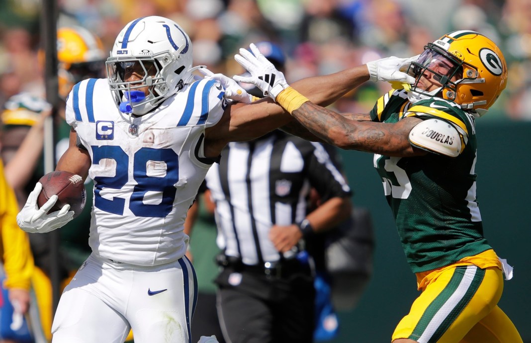 Indianapolis Colts running back Jonathan Taylor (28) stiff arms Green Bay Packers cornerback Jaire Alexander (23) on a first down run during their football game on Sunday, September 15, 2024, at Lambeau Field in Green Bay, Wisconsin.