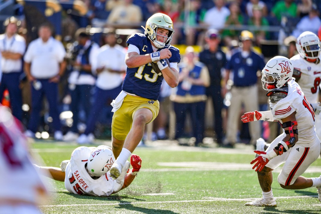 Notre Dame Fighting Irish quarterback Riley Leonard (13) runs for a touchdown while Miami Redhawks linebacker Matt Salopek (15) defends during the second quarter at Notre Dame Stadium on September 21, 2024.