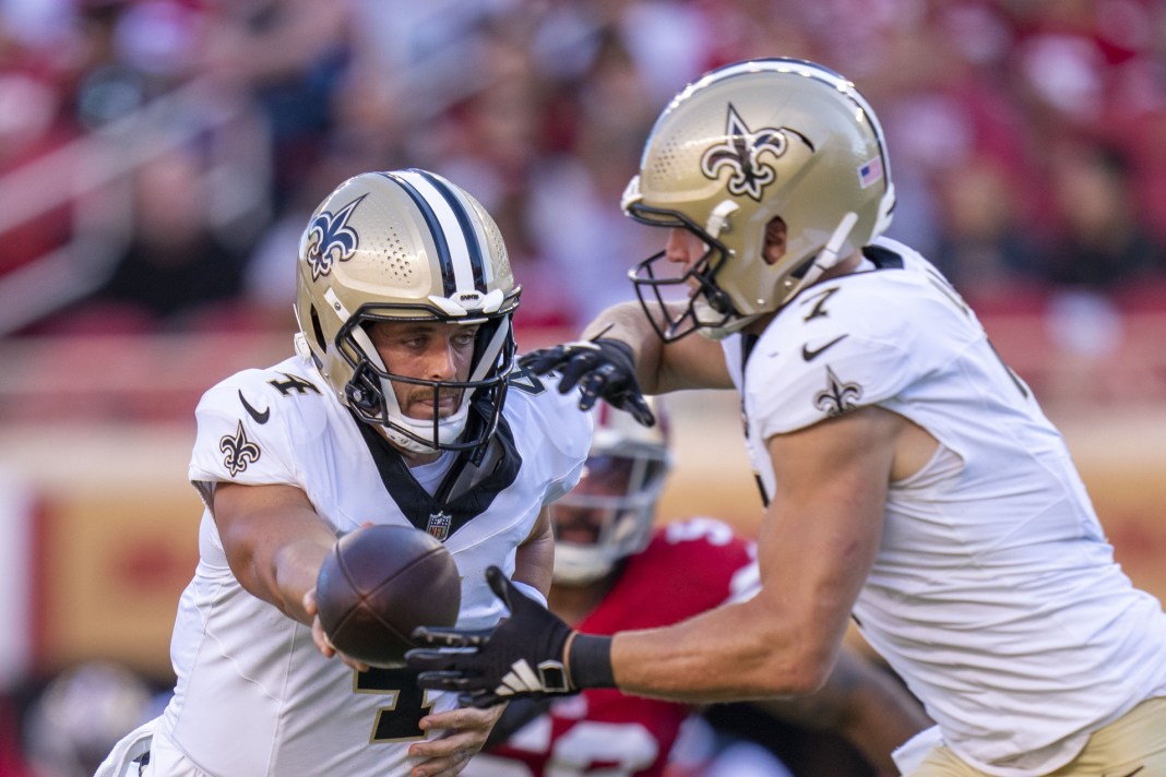 New Orleans Saints quarterback Derek Carr (4) hands off the football to quarterback Taysom Hill (7) during the first quarter of the game against the San Francisco 49ers at Levi's Stadium on August 18, 2024.