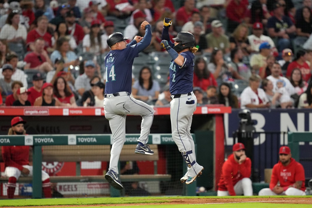 Seattle Mariners first baseman Justin Turner (2) celebrates with third base coach Manny Acta (14) after hitting a home run in the fourth inning against the Los Angeles Angels at Angel Stadium on August 31, 2024.