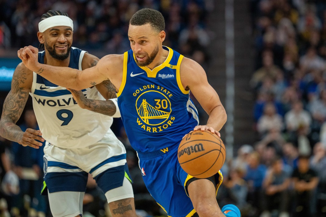 Golden State Warriors guard Stephen Curry drives to the net against Minnesota Timberwolves guard Nickeil Alexander-Walker