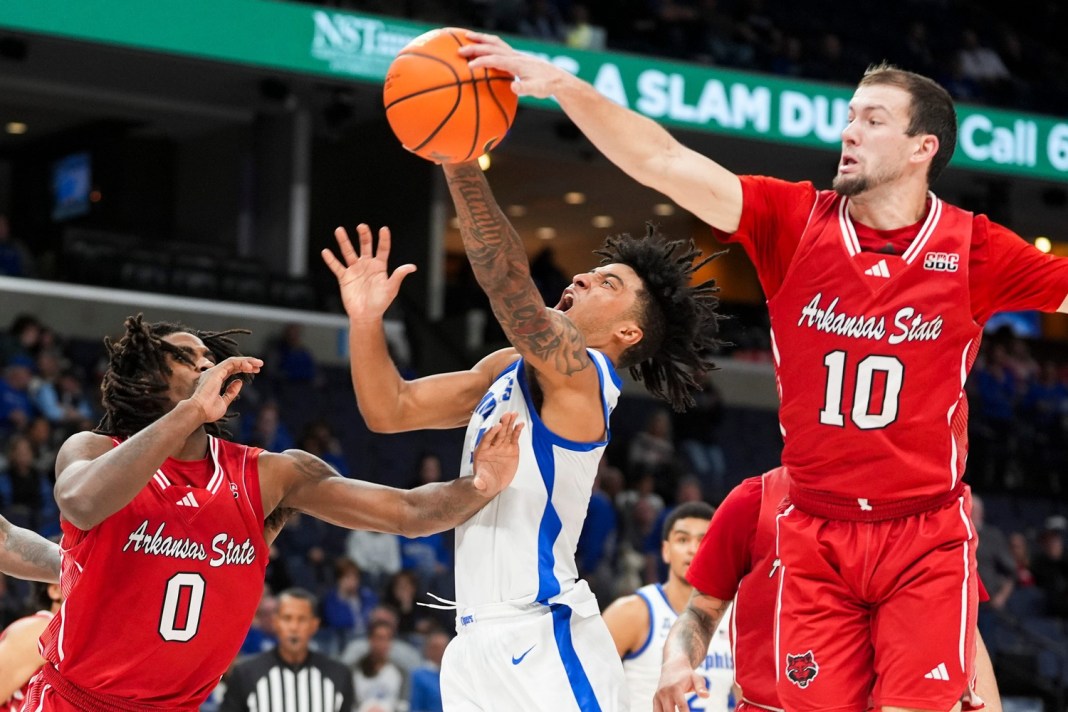 Memphis' PJ Haggerty (4) is blocked by Arkansas State's Avery Felts (10) as he goes for a layup during the game between Arkansas State University and the University of Memphis at FedExForum in Memphis, Tenn., on December 8, 2024.