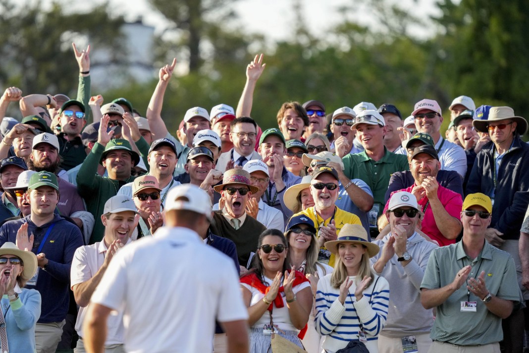 Fans cheer for Bryson DeChambeau on the 18th green during the third round of the Masters Tournament at Augusta National Golf Club in Augusta, Georgia, on April 12, 2025.