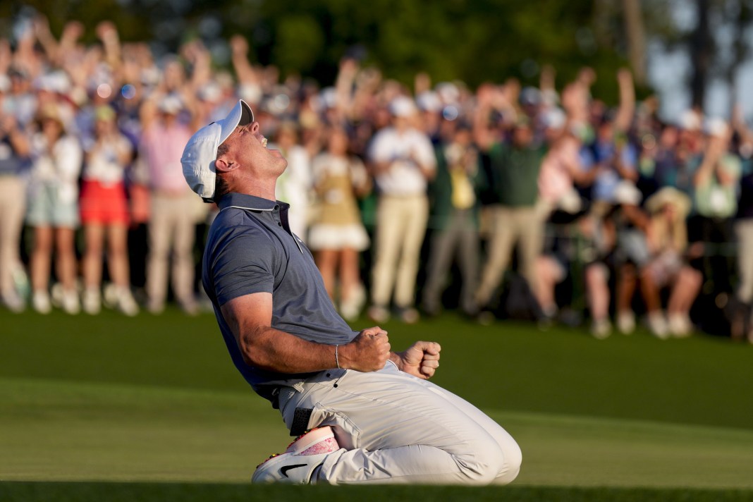 Rory McIlroy falls to his knees in celebration after winning a playoff on the 18th green during the final round of the Masters Tournament at Augusta National Golf Club in Augusta, Georgia, on April 13, 2025.