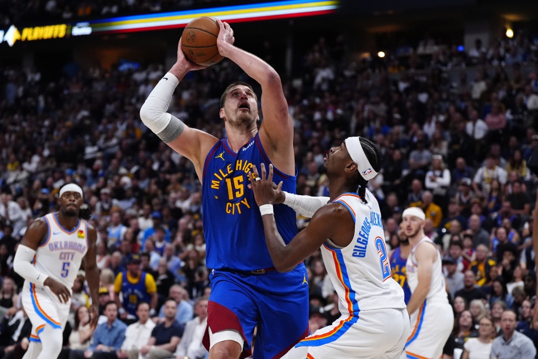 Nuggets superstar Nikola Jokic goes up with a shot over Shai Gilgeous-Alexander during the 2024-25 NBA Playoffs.