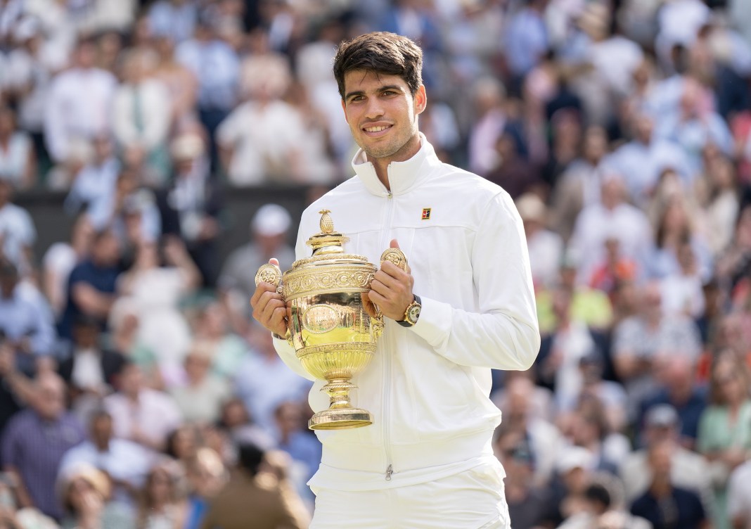 Carlos Alcaraz celebrates with the Wimbledon trophy in 2024.