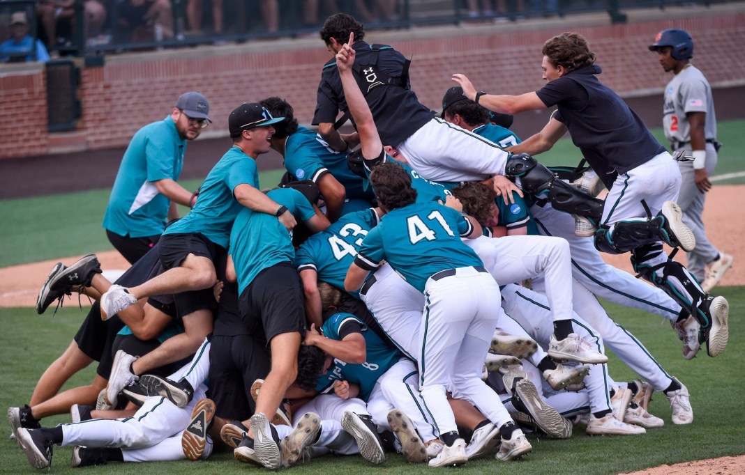 Coastal Carolina players celebrate in a dogpile after winning the Auburn Super Regional, securing their spot in the 2025 College World Series.
