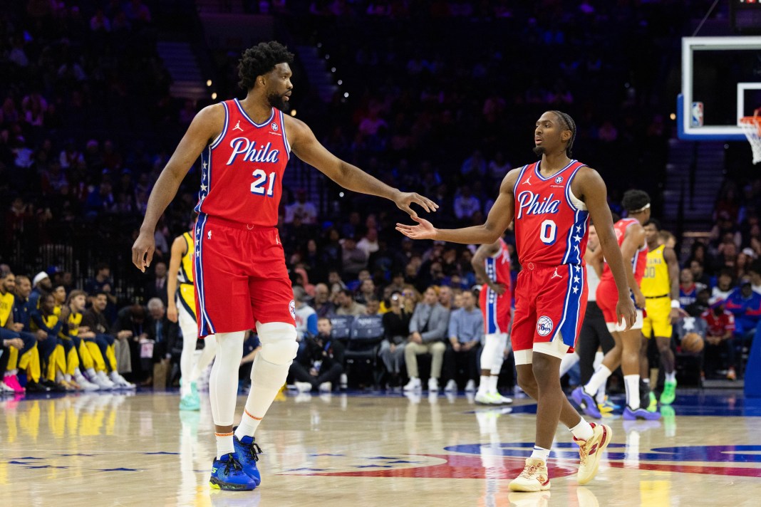 Sixers stars Joel Embiid and Tyrese Maxey high five during the 2024-25 NBA season.