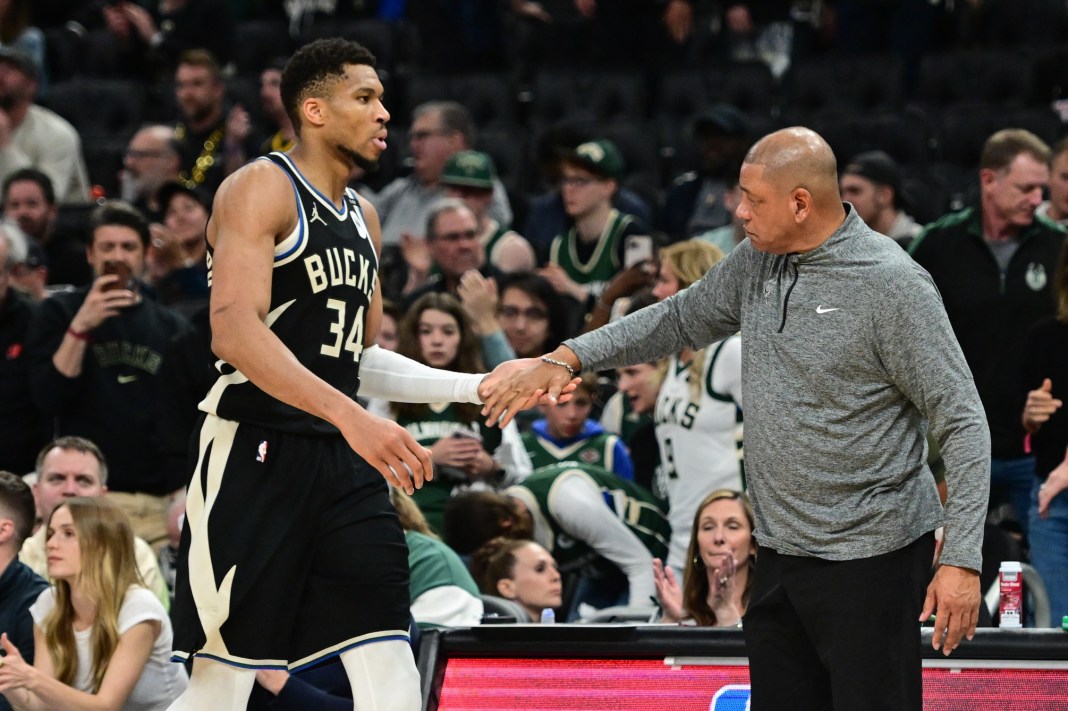 Bucks star Giannis Antetokounmpo high fives Doc Rivers during the 2024-25 NBA Playoffs.